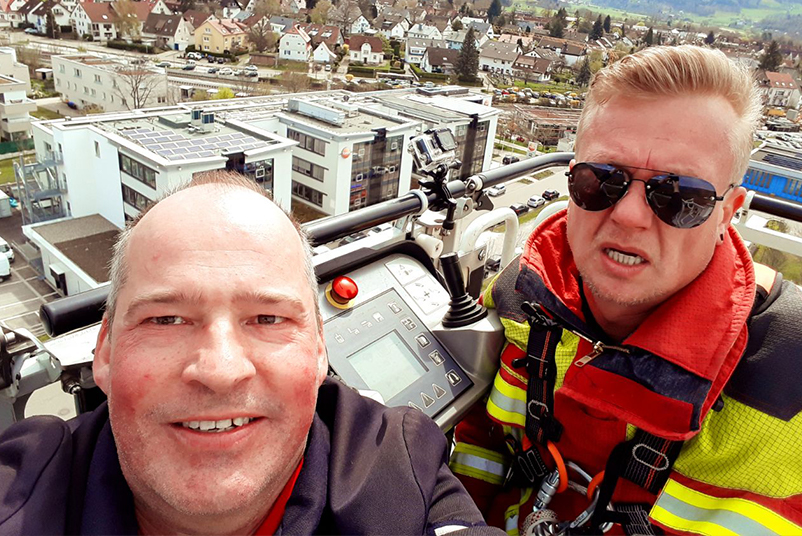 Ein Testo-Mitarbeiter auf der Feuerwehrdrehleiter mit einem Radio-Moderator bei einer Wette.  