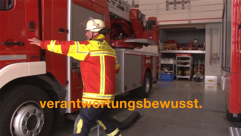 Ein Feuerwehrmann steigt in das Feuerwehrauto