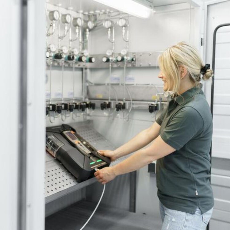Rauchgas Kalibrierung eines Testo-Rauchgasmessgeräts durch eine Mitarbeiterin