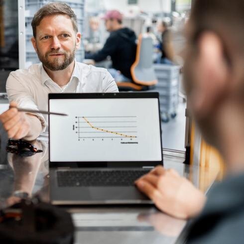 Herausforderung Kalibrierzyklus – das richtige Kalibrierintervall wählen Ein Mann erklärt am Laptop das Punktemodel zur Definition des Kalibrierintervalls