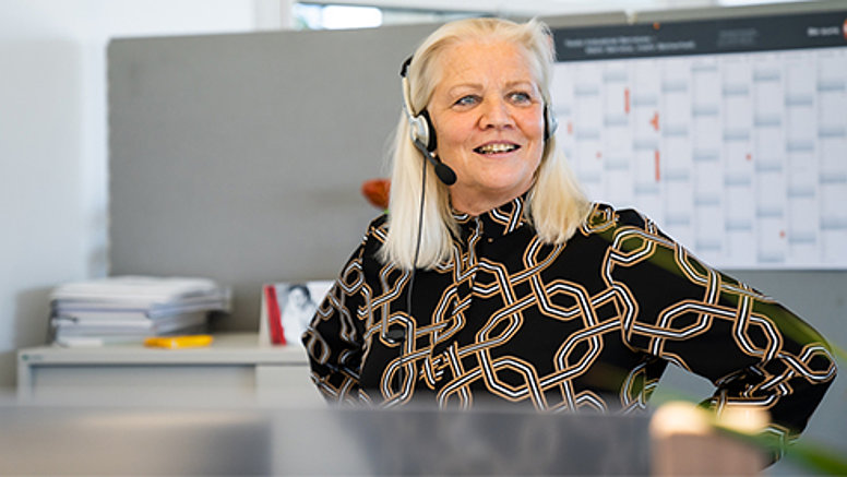 Elke V., zuständig für Events & Seminare, telefoniert lachend.