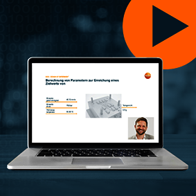 Webinar – Prozessoptimierung mittels DoE (Design of Experiment) Screenshot des Webinars mit Foto des Referenten auf dem Bildschirm eines Laptops vor blauem Hintergrund